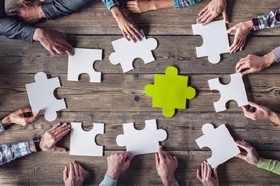 Modulstudium - Gruppe am Tisch mit Puzzle