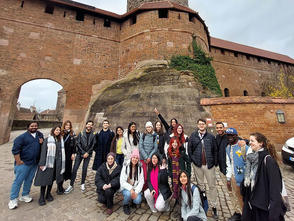 International Studierende vor Stadtmauer
