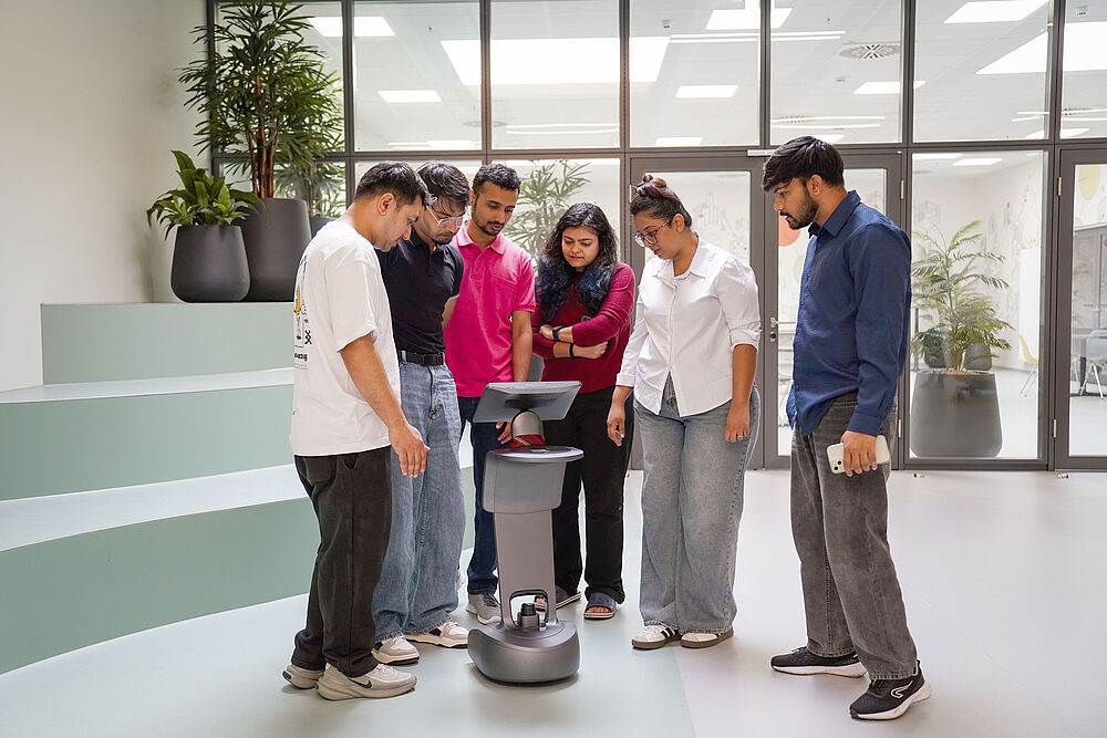 [Translate to English:] Studierende mit Roboter